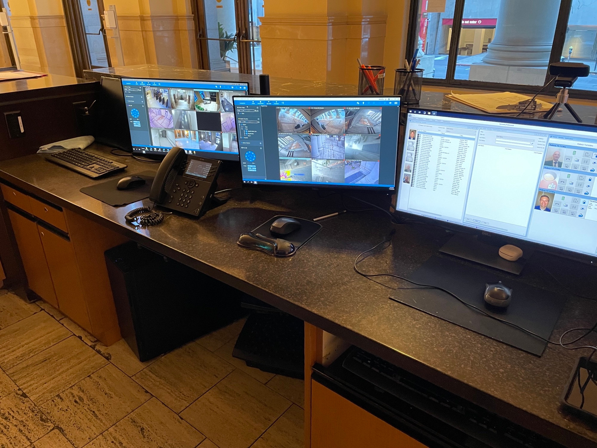 Photo of a front desk with three computers monitoring security