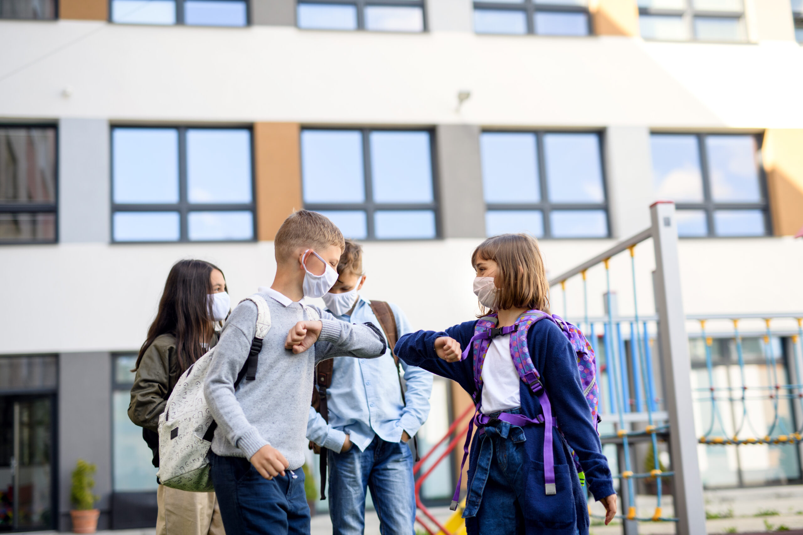 Children with face mask going back to school after covid-19 quarantine and lockdown, greeting.